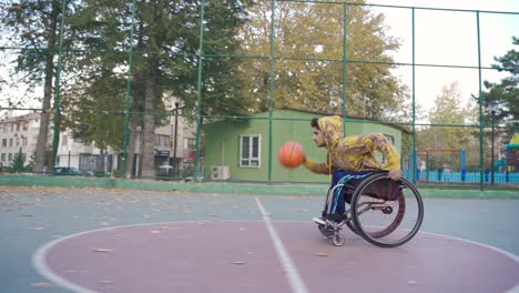 Un-Joven-Discapacitado-Determinado-Juega-Baloncesto-En-La-Cancha-De-Baloncesto-Al-Aire-Libre.